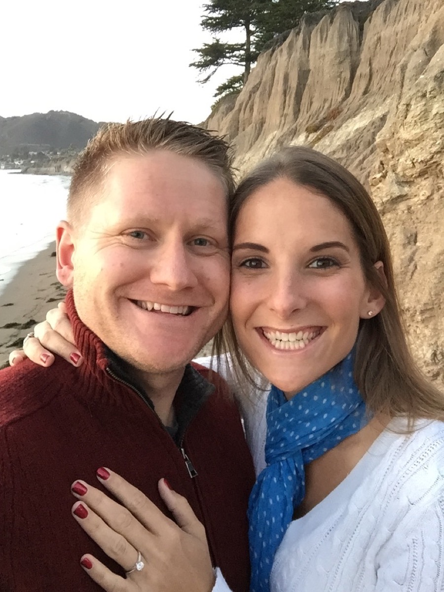 Kyle and Kate on the beach showing the engagement ring