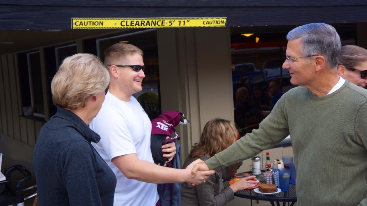 Kyle shaking Mark Granich's hand while holding Drifter