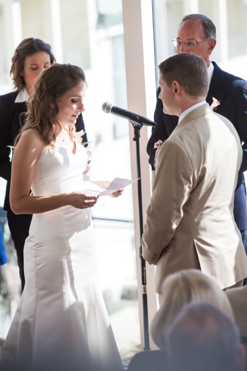 Kate reading her vows from paper at the microphone
