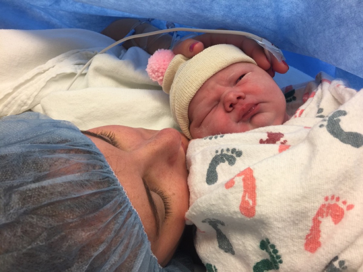 Kate holding newborn Makena cheek to cheek in the hospital