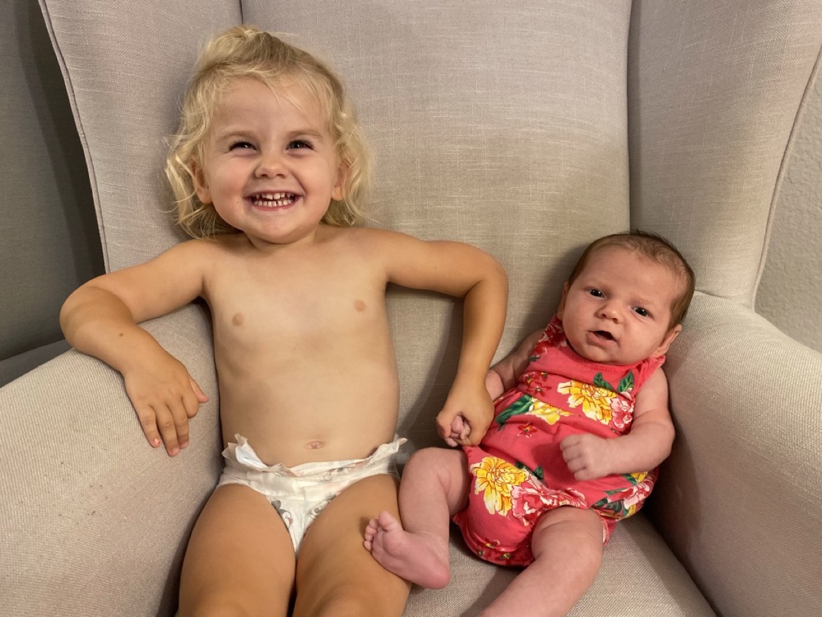 Makena and Morgan sitting together in a chair holding hands