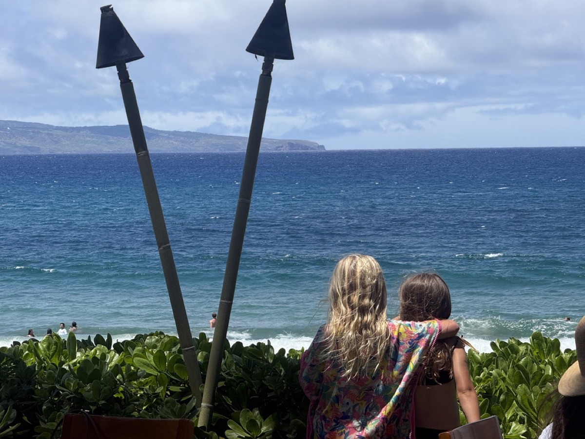 Makena and Morgan with arms around each other looking at the ocean in Maui