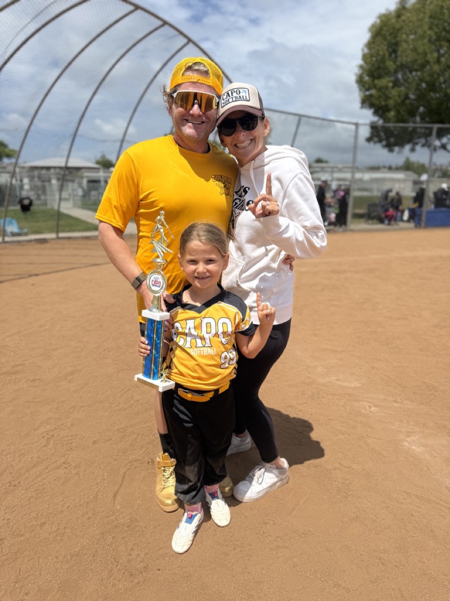 Morgan holding a softball trophy with Kate and Kyle on the field after winning 6U regular season
